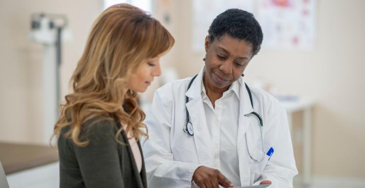 woman in exam room looking at results with doctor