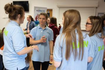 Group of young girls stood in a circle chatting 